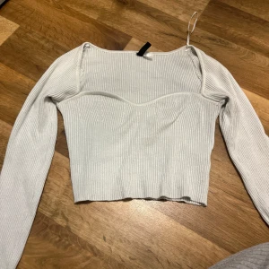 Vit ribbad topp - Snygg vit ribbad topp från H&M med långa ärmar och en croppad design. 