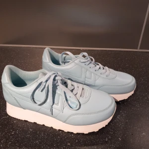 Ljusblå sneakers  - Snygga ljusblå sneakers med vit hög sula och klassisk snörning. Helt oanvända. 