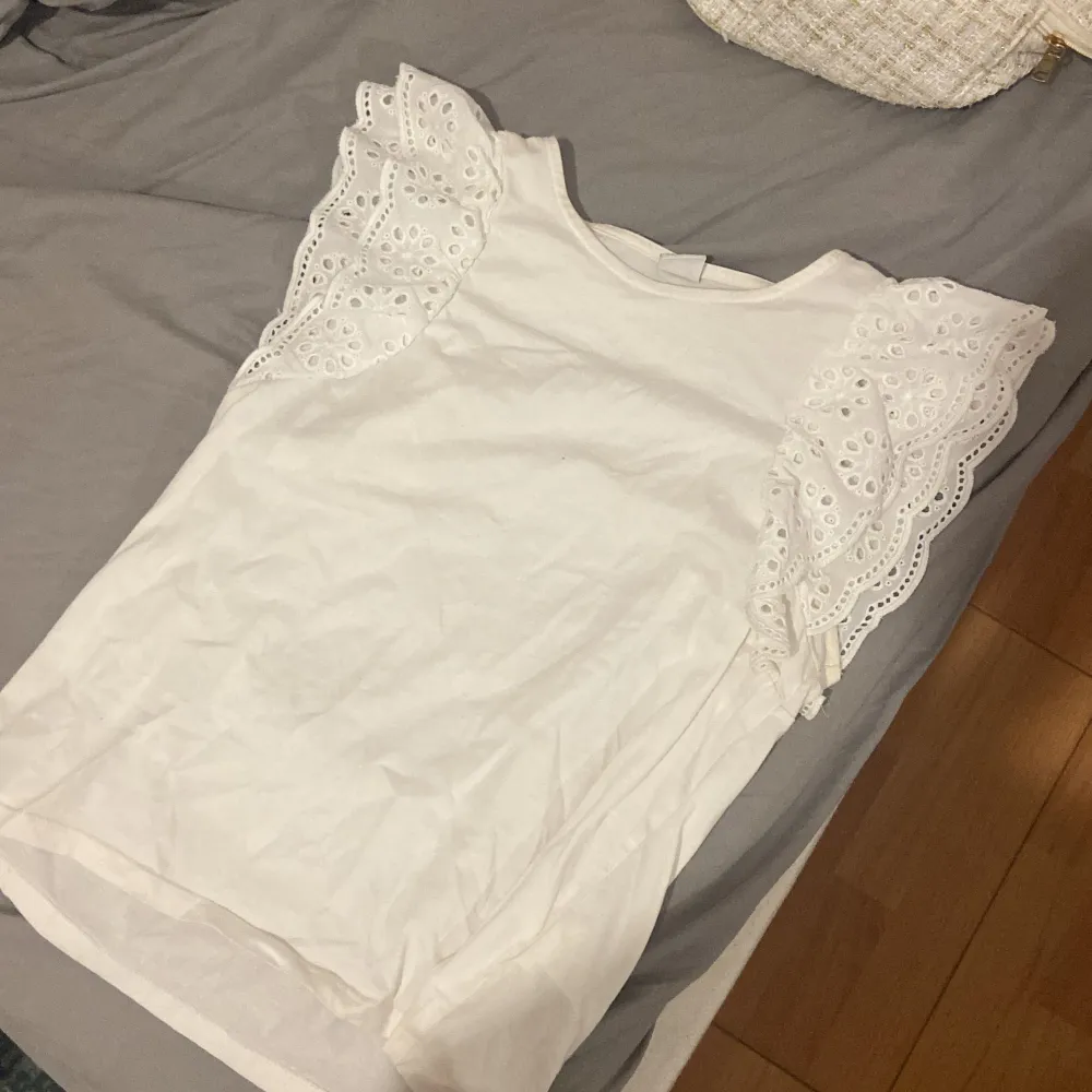 Säljer en söt vit topp från Lindex med fina spetsdetaljer på ärmarna. den är i bra skick. är i storlek 146-152 men passar xs🩷. Yläosat.