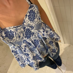 Topp - Fin blommig volangtopp, axelbanden är lite insydda på framsidan och finns en liten fläck som ej går bort men som knappt syns💕 strl s