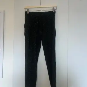 Säljer ett par gröna leggings med ett subtilt mönster. De är högmidjade och har en tight passform. Perfekta för både träning och vardagsbruk. Materialet är mjukt och stretchigt, vilket gör dem bekväma att ha på sig hela dagen.