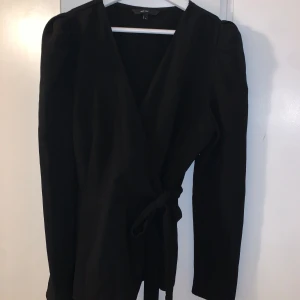 Långärmad blus från Vero Moda  - Blusen är i tjockare material och är lite stretchig. Har inga axelvaddar. Har knytdetalj på sidan samt dragkedja. Är liten i storlek och passar M-L. 