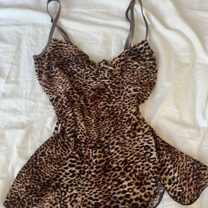Leopard linne från 2000s talet - Säljer detta snygga leopard linnet från 2000s talet. står ingen storlek eller någon lapp men passar som S. superskönt material. En liten defekt är att det brukade sitta en blomma som trillade bort i tvätten (se på bild 2) annars i bra skick.