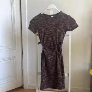 Mörk kortklänning från H&M Divided - Säljer en mörk kortklänning från H&M Divided i storlek XXS. Klänningen har korta ärmar och ett snyggt knyt i midjan som ger en fin passform. Materialet känns mjukt och bekvämt, perfekt för både vardag och fest. Den har ett diskret mönster i olika mörka nyanser som gör den lätt att matcha med olika accessoarer. frakten blir 54kr hemleverans (icke spårbart) 🤗