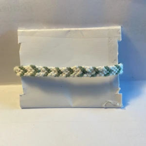 Armband -  Har gjort armband i bomull skan, man kan ändra storleken elva till 19 cm, 0,5 cm brett. Armbandet är mörkgrönt och vitt.