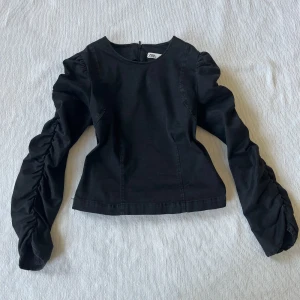 Svart topp från Zara - Ärmar med rynkade detaljer och en dragkedja i ryggen. Fint skick!