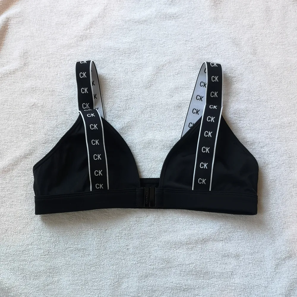 Svart bikini top från Calvin Klein i strl XS. Den har en knäppning på framsidan och breda axelband med CK-loggan på. Använd ett fåtal gånger. ***Köpare står för frakt. Toppar.