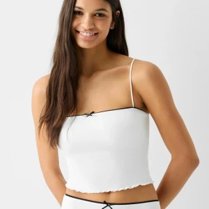 Vitt linne  - Vitt linne med svart detalj från bershka. Väldigt skön och behaglig i materialet. Använd inte enstaka gång så i bra skick. 