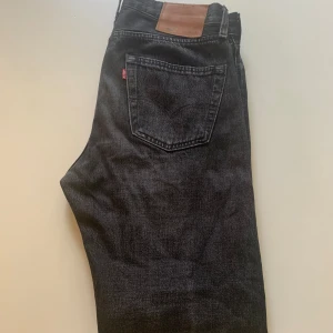 Svarta jeans från Levis - Säljer ett par svarta jeans som har en skön tvätt från Levis. Inte mycket använda så i väldigt bra skick. Passformen är mellan slim och straight