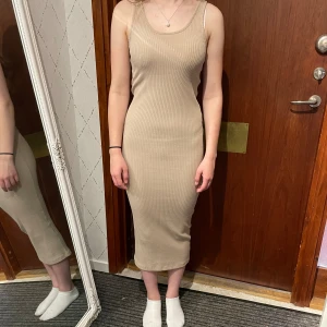 Ribbad klänning - Beige ribbad klänning från Hm, aldrig använd.