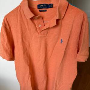 Orange pikétröja från Ralph Lauren i storlek L. liten i storleken. Använd en del men inga större skador