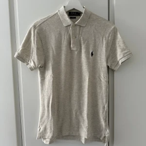 Ralph Lauren Piké - (KÖP BÅDA FÄRGERNA FÖR 500kr)  En beige Ralph Lauren piké i storleken S. Knappt använd och inga defekter. Nypris ≈ 1000kr. Säljer då den inte längre passar mig. 