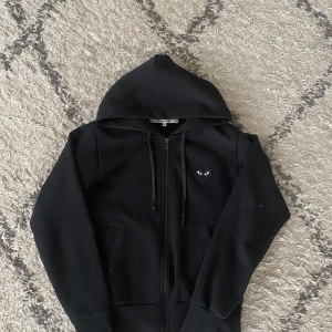 CDG Hoodie  - Jag säljer denna snygga hoodie då den är väldigt liten, jag ör 179 o väger 70. Den är i bra skick utan några hål eller fläckar. De är storlek S men passar  mindre mycket bättre.  tveka inte att hör av er vid yttligare frågor!☺️