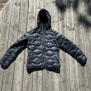 Svart dunjacka från Peak Performance - Säljer en svart dunjacka från Peak Performance. Jackan är i bra skick och har en dragkedja framtill samt en huva. Perfekt för kalla vinterdagar. Den är quiltad och har en normal passform. Köp direkt eller ge prisförslag 💛