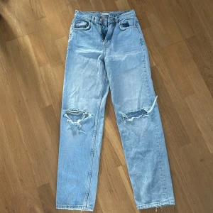 Ljusa jeans med slitningar - Snygga ljusblå jeans från Perfect Jeans med slitningar på knäna. De har en klassisk femficksdesign och stängs med dragkedja och knapp. Perfekta för en avslappnad stil.