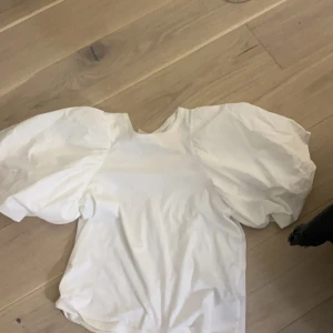 Vit topp med puffärmar från Selected - Säljer en  vit topp från Selected med stora puffärmar. Inga skador använd gärna köp nu, kan mötas upp i Sthlm!