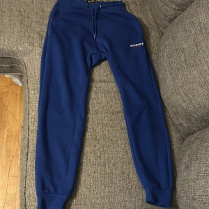 Blå mjukisbyxor från McKenzie - Säljer ett par blå mjukisbyxor från McKenzie med snörning i midjan. Perfekta för en avslappnad stil. Byxorna har elastiska muddar vid bensluten och en bekväm passform.