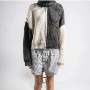 Tvåfärgad stickad polotröja - Säljer en mysig stickad polotröja i två färger, grå och vit. Tröjan har en oversized passform med långa ärmar och en hög polokrage. 