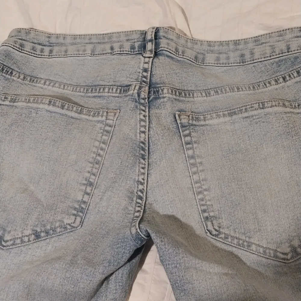 Snygga bootcut jeans i ljusblå denim med slitna detaljer. De har en låg midja och klassisk femficksdesign. Perfekta för en avslappnad stil.. Farkut & Housut.