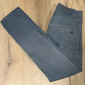 Dondup jeans - Snygga grå jeans med coola slitningar på framsidan. De har en klassisk femficksdesign och knappar i midjan. Perfekta för en avslappnad stil med en touch av edge.