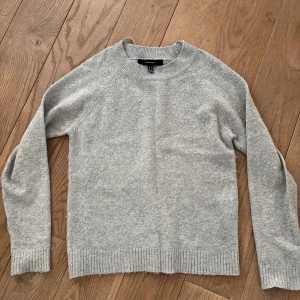 Grå stickad tröja från Vero Moda  - Säljer en stilren grå tröja från Vero Moda. Den är mjuk och bekväm med långa ärmar och ribbade kanter vid ärmslut och nederkant. Perfekt för kyligare dagar! Den är använd men har inga skador förutom att den har blivit lite knopprig