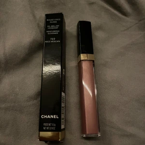 Chanel Rouge Coco Gloss 722 Noce Moscata - Chanel Rouge Coco Gloss i nyansen 722 Noce Moscata. Ett återfuktande läppglans med en elegant brunrosa ton. Perfekt för att ge läpparna en glansig och sofistikerad look.