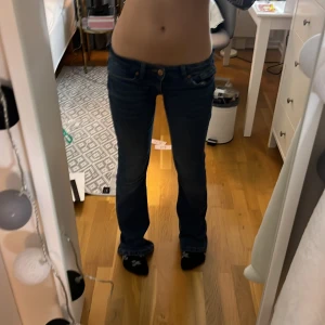 Blå bootcut jeans - Säljer ett par snygga blå bootcut jeans med låg midja. Perfekta för en avslappnad stil. De har klassiska fem fickor och en knappgylf. Sjukt snygga och sköna❤️ Ny pris: 500kr