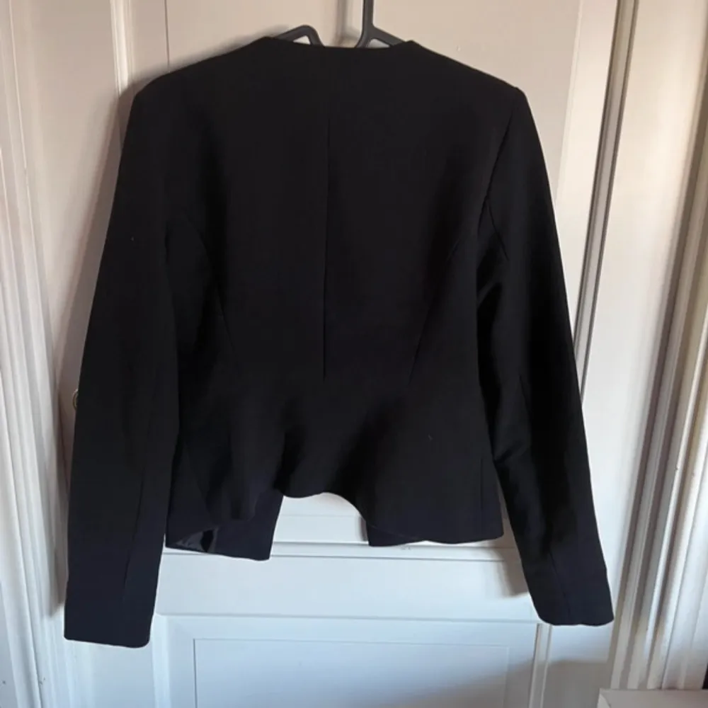 Snygg svart kavaj från ONLY i storlek 34. Kavajen har en stilren design med dragkedjor framtill och långa ärmar. Perfekt för en chic och elegant look.. Puvut & Bleiserit.