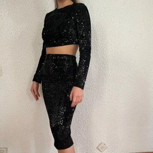 Svart Paljett Set M - Magtröja + kjol, storlek M. Från Nelly. Svart paljettset. Använt typ 1 gång. 💕