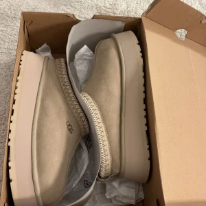 UGG Tazz slipper  - Intressekoll på mina superfina Uggs i modellen tazz i färgen mustard seed. De är i storlek 39 men skulle säga det passar både en 38 och 39, jag har 38 och de passar mig. Är i jättebra skick då jag endast använt några få gånger har kartong kvar! Slutsålda överallt. Hör gärna av er vid intresse och frågor. 