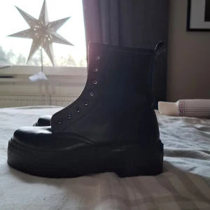 Svarta boots  - Svarta boots utan fodring. Skorna är oandvända och saknar snörning. 