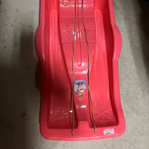 Röd pulka för barn - Det är en jätte bra pulka som barn kan åka. Den är rosa och är i ett jätte bra kvalitet. Den är jätte bra på vinter när det fanns snö .