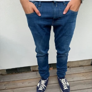 Replay jeans - Säljer ett par mörkblå Replay Anbass jeans i bra skick. De är slim fit och ger en snygg passform. Skicket är väldigt 9/10 med bara små små defekt på baksidan av byxan. Hör av dig vid frågor och funderingar 