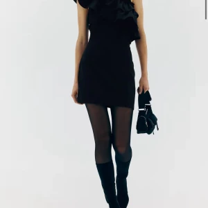 Svart oneshoulder klänning med volang - Elegant svart oneshoulder klänning med volangdetaljer. 