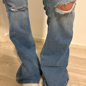 Blå bootcut jeans med slitningar - Snygga blå bootcut jeans med slitningar på knäna. Högmidjade och väldigt fin passform! Endast testade! 👖