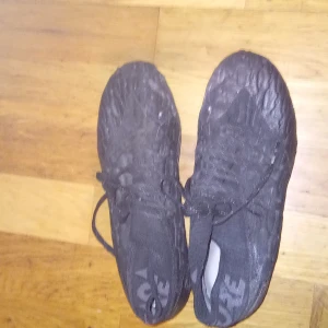 Svarta fotbollsskor från Puma - Säljer ett par svarta fotbollsskor från Puma med snörning och dobbar för bra grepp på planen. Perfekta för fotbollsträning och matcher.