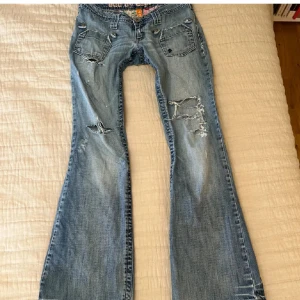 Blå bootcut jeans med slitningar - Midja: ca 41 innerben: ca 78. Säljer världens snyggaste low waist bootcur jeans. De är väldigt håliga. De har ett ganska stort hål på rumpan (se bild 2). Vet inte om det går att sy igen men så köparen vet! Otroligt otroligt snygga. Står strl 4, uppskattar till 38. Jag på bilden är 162. Säljes endast för priset som angetts, inte lägre. Smått smutsiga vid fötterna. Skriv vid frågor eller intresse🎀