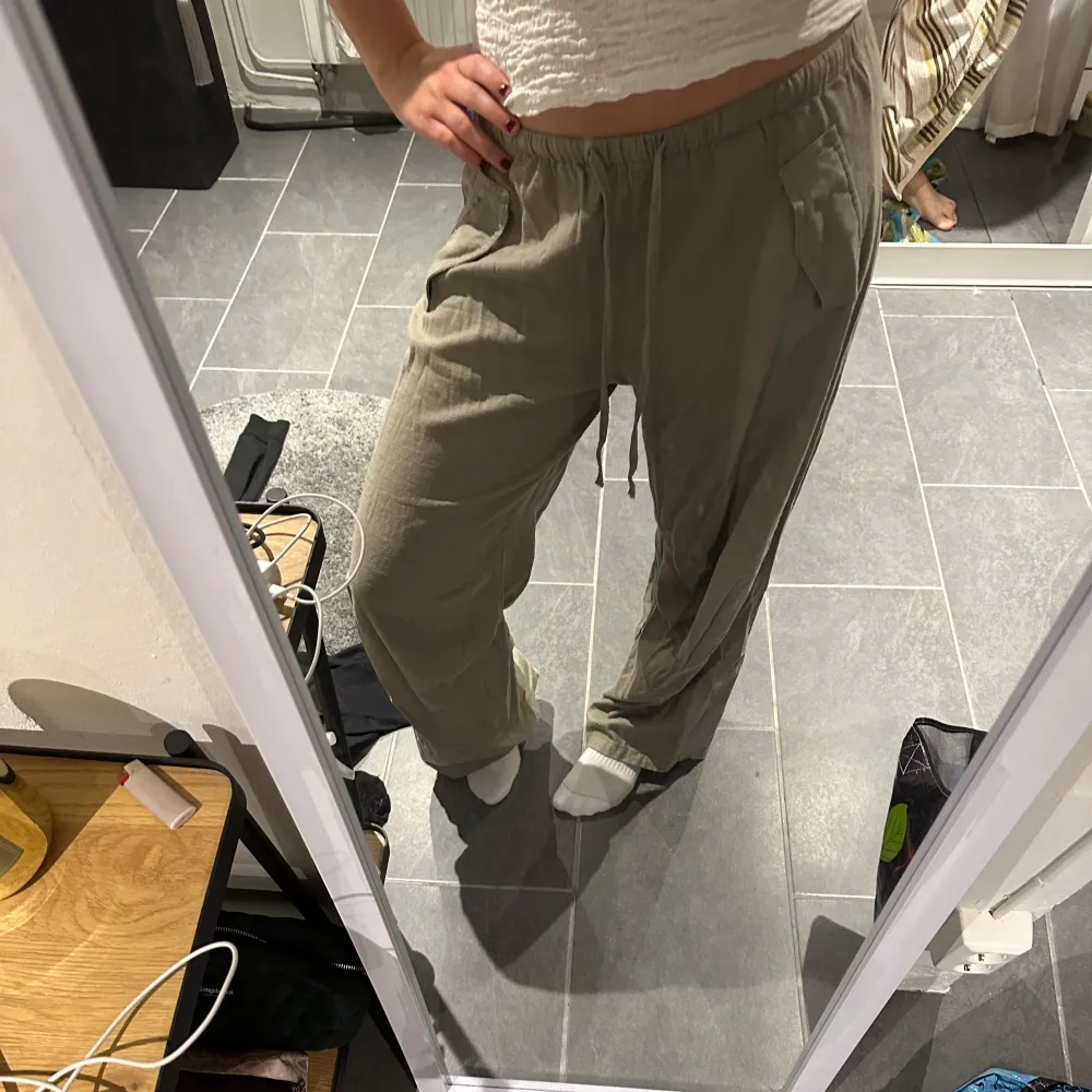 Säljer ett par bekväma beige byxor från Pull&Bear. Byxorna har en loose passform med elastisk midja. Perfekta för en avslappnad stil. Aldrig använda. Farkut & Housut.