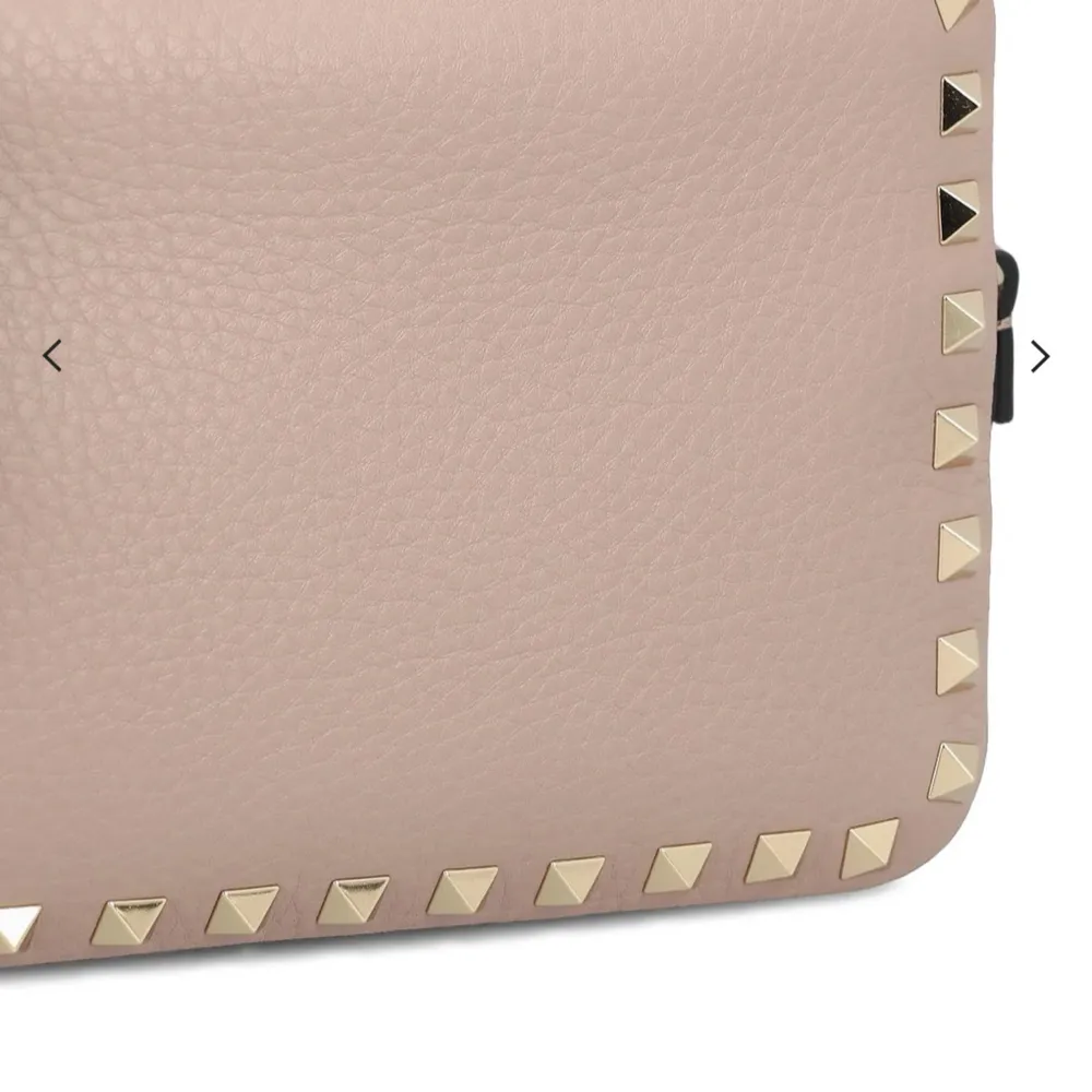Snygg beige axelväska från Valentino med guldfärgade nitar runt kanterna. Väskan har en justerbar axelrem och är perfekt för att ge en edgy touch till din outfit. Väskan är äkta då de går att kolla upp. Köpte av en tjej på Plick där äktighets bevis fanns! Ser ut som ny och har inga defekter💗. Laukut & Käsilaukut.