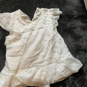 Vit blus från Gina Tricot - Säljer en söt vit blus från Gina Tricot. Blusen har korta ärmar och fina spetsdetaljer. Perfekt för en somrig look!❤️💕❤️skriv för fler bilder 💕💕❤️