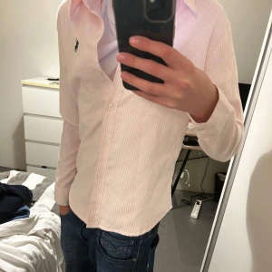 Rosa randig skjorta från Ralph Lauren - Snygg rosa randig skjorta från Ralph Lauren. Inga defekter eller liknande, priset kan diskuteras.plagget passar 160-170 cm