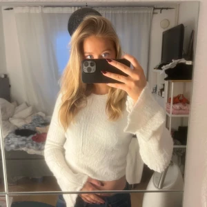 Vit croppad tröja - Säljer en stilren vit croppad tröja med långa ärmar. Perfekt för en avslappnad look. Tröjan har en mjuk och bekväm passform.