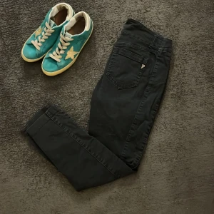 Svarta byxor från Dondup - Snygga svarta byxor från Dondup med en klassisk design. Byxorna har en smal passform och är tillverkade i ett bekvämt material. Perfekta för en stilren look. byxorna borde nog passa dig som är runt 170 cm lång och de har en slim passform som passar perfekt till grisch stilen 