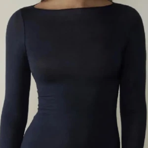 Mörkblå långärmad topp - Elegant mörkblå topp med lång ärm och en tight passform. Perfekt för en stilren look.