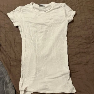 Vit kortärmad t-shirt - Säljer en enkel och stilren vit kortärmad t-shirt. Perfekt basplagg för alla tillfällen. T-shirten har en rund hals och är gjord i ett mjukt material.🩷