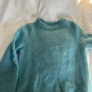 Ljusblå stickad tröja från H&M - Väldigt fin ljusblå stickad tröja från H&M. Perfekt för kyliga dagar med sin mjuka och bekväma passform. Tröjan har långa ärmar och en rund halsringning. Använd ungefär tre gånger💗