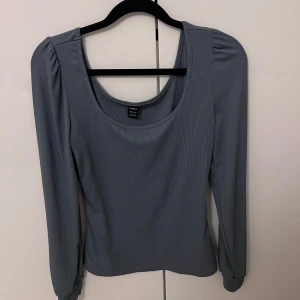 Blå ribbad topp från Shein - Säljer en stilren grå ribbad topp från Shein. Toppen har långa ärmar och en rundad halsringning, perfekt för en avslappnad look. Passar bra till både jeans och kjol.