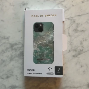 Azura Marble mobilskal från IDEAL OF SWEDEN - Snyggt mobilskal i Azura Marble-design från IDEAL OF SWEDEN, kompatibelt med iPhone 13 och 14. Skalet har en elegant marmorerad yta i gröna och vita toner, tillverkat av återvunna material. Perfekt för att ge din telefon ett stilrent och unikt utseende. Just nu slut i lager. Nypris 349kr. Helt oanvänd pga av jag har en annan model på telefon.💘💘