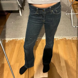 Mörkblå jeans från Base - Snygga mörkblå jeans från Base med klassisk femficksdesign och kontrasterande sömmar. De har en knapp och dragkedja framtill och är perfekta för en avslappnad stil. Passar bra till både sneakers och kängor.