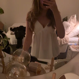 Vit topp - Säljer en söt vit topp med spetsdetaljer då den ej kommer till användning. Toppen har en luftig passform och v-ringad design, perfekt för varma dagar. Pris kan diskuteras. Helt oanvänd, med lappen kvar.